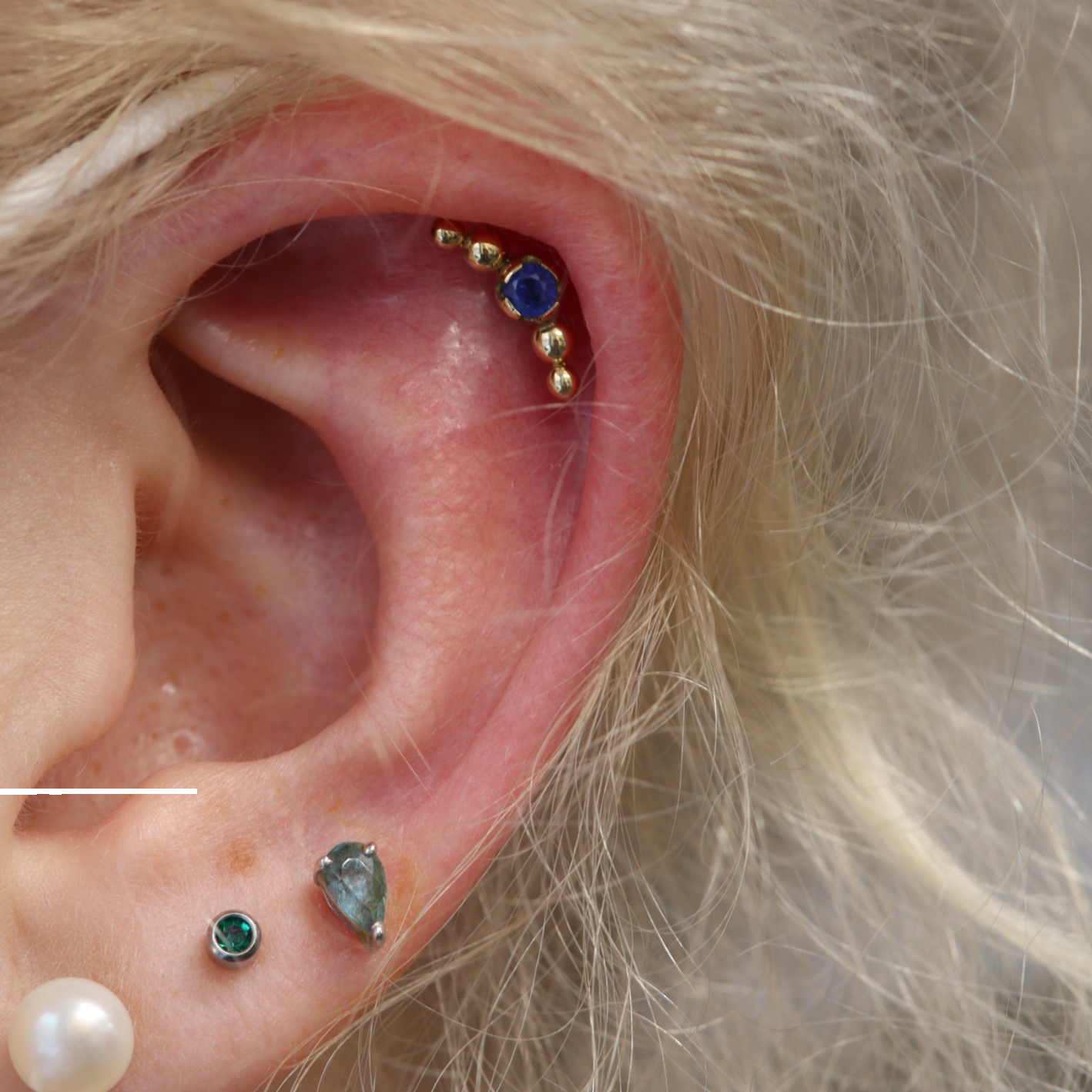 Helix piercing with Companion end in 18k yellow gold and sapphire from Ixus fine jewellery